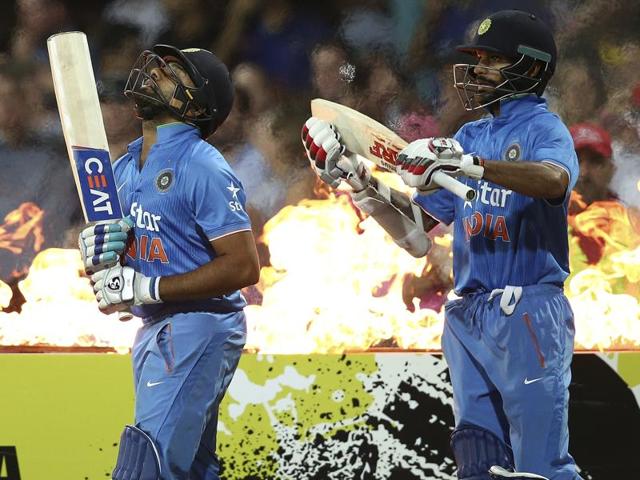 Indian batsmen Rohit Sharma and Shikhar Dhawan walk onto the field during their T20 International cricket match. (AP Photo) 