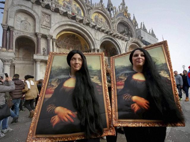 Two carnival revellers masquerade as Leonardo da Vinci’s painting ‘Mona Lisa’ pose in St. Mark’s Square in Venice, Italy, on January 31, 2016. (AP) 