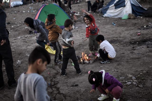 This file photo taken on November 4, 2015 shows refugee and migrant children, living in a field next door to the Moria camp on the Greek island of Lesbos, wait to be registered in Mytilene. (AFP)
