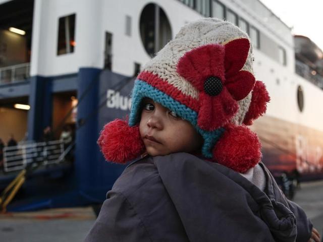 A baby in front of a ferry at the port of Piraeus near Athens, Sunday, Jan. 31, 2016. Over one million migrants and refugees, many fleeing the Syria conflict, crossed into Europe last year.(AP)