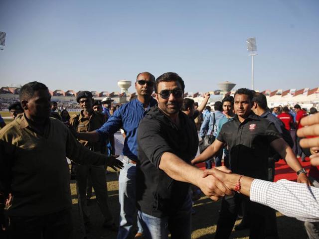 Bollywood actor Sunny Deol shakes hands with fans during the Celebrity Cricket League. (AP) 