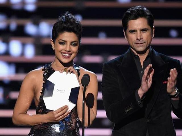 Priyanka Chopra (Quantico) and John Stamos (Grandfathered) accept their awards for favourite actor and actress in a new TV series before presenting the award for favourite movie at the People’s Choice Awards 2016 . (Reuters)
