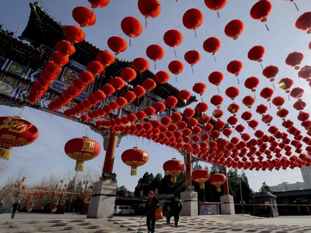 People walk past an entrance gate of Ditan Park decorated with red lanterns ahead of the Chinese Lunar New Year in Beijing.  (AP) 