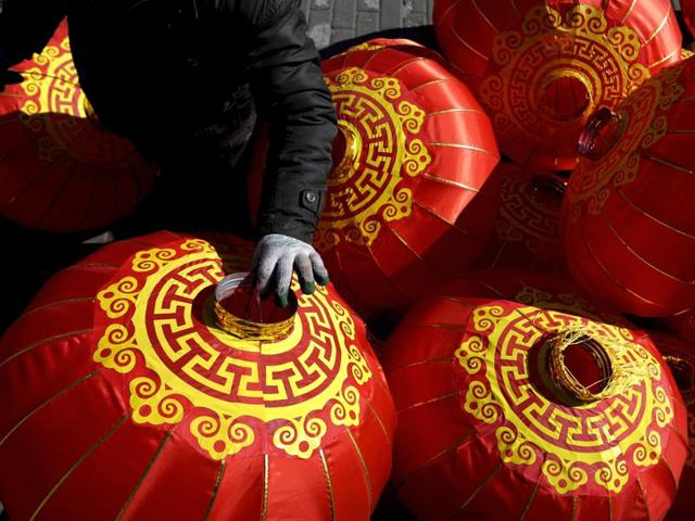 A worker prepares to set up Chinese lanterns to decorate on a street in Beijing. The new year date differs from the Gregorian calendar each year. It generally falls between January 21 and February 20 from the Gregorian calendar. (AP) 