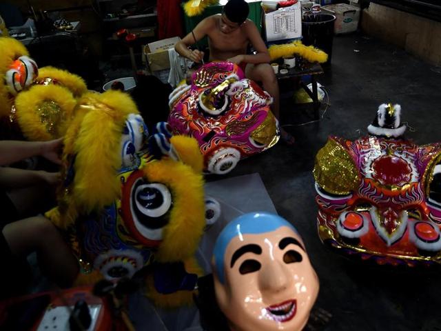 Malaysian craftsmen give finishing touches to traditional lion-head masks at a workshop in Subang on February 2, 2016.  (AFP) 
