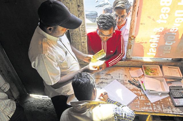 Commercial vehicle operators queue up at the toll booth on MG Road to get their monthly passes on Monday. (Abhinav Saha)