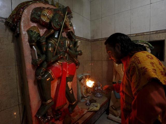 A priest holds an oil lamp to offer prayers in front of a deity at the Shri Panchmukhi Temple in Karachi. (REUTERS File Photo) A priest holds an oil lamp to offer prayers in front of a deity at the Shri Panchmukhi Temple in Karachi. (REUTERS File Photo)