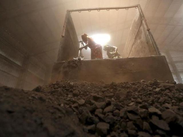 Workers unload coal from a supply truck at a yard on the outskirts of Ahmedabad. (Reuters)