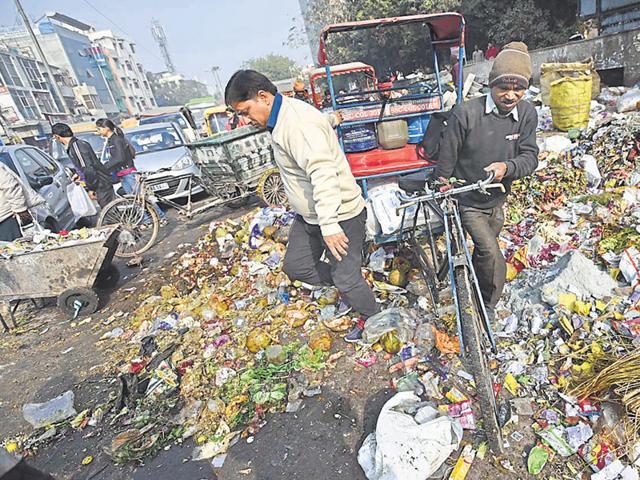 A man tries to cross a garbage-strwen road in east Delhi’s Laxmi Nagar on the second day of the municipal strike. (Arun Sharma/ HT photo) A man tries to cross a garbage-strwen road in east Delhi’s Laxmi Nagar on the second day of the municipal strike. (Arun Sharma/ HT photo)