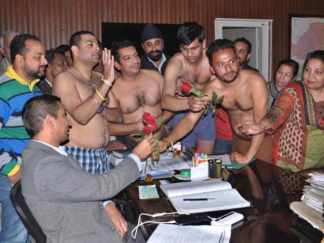 Taking off their clothes as mark of the protest, residents of Bawa Colony presenting flowers to a municipal corporation official in Ludhiana on Thursday. (Sikander Singh Chopra/HT) Taking off their clothes as mark of the protest, residents of Bawa Colony presenting flowers to a municipal corporation official in Ludhiana on Thursday. (Sikander Singh Chopra/HT)