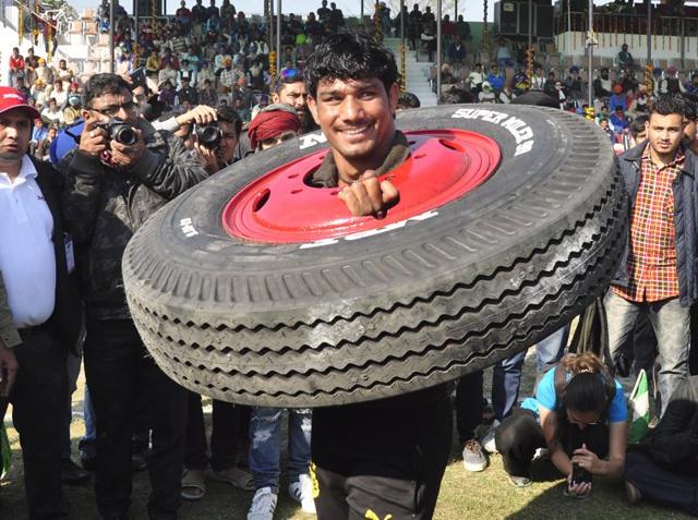 TAKING LIGHT: A man shows off his strength by lifting a tyre during the 80th Kila Raipur Rural Games Festival near Ludhiana on Friday. (Sikander Singh Chopra/HT Photo)
