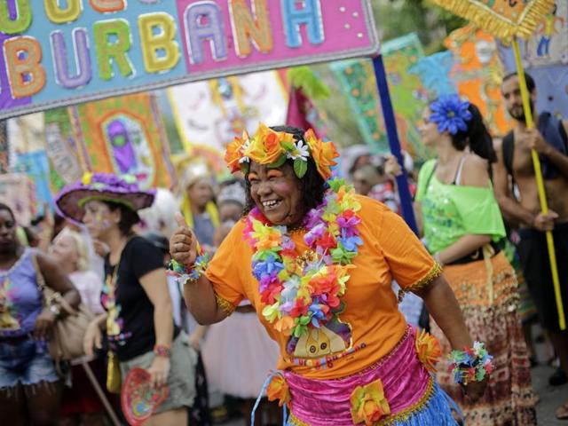 A patient from the Nise de Silveira mental health institute dances in costume during the institute's carnival parade, called in Portuguese: "Loucura Suburbana," or Suburban Madness, in the streets of Rio de Janeiro, Brazil. (AP) 
