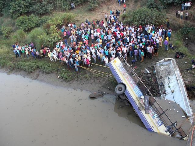 Locals gather in an attempt to rescue injured and recover bodies of passengers from the wreckage of the bus, in Navsari district of Indian state of Gujarat, Friday, Feb. 5, 2016.(AP)