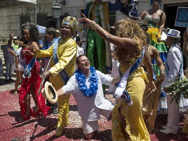 Rio de Janeiro's Mayor Eduardo Paes, center, dances with and the 2nd princess of the carnival, Bianca Monteiro, right, and the 2016 Carnival King Momo, Wilson Dias da Costa Neto,second left, at a ceremony marking the official start of Carnival in Rio de Janeiro, Brazil. (AP) 