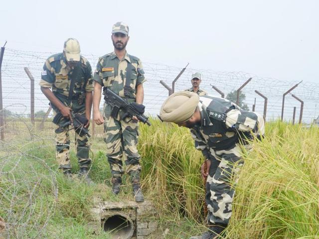 BSF personnel inspect the body of one of the four smugglers shot dead along the Indo-Pak border. Ten kilograms of contraband, arms and Pakistani currency was seized from the smugglers’ possession. (PTI Photo) BSF personnel inspect the body of one of the four smugglers shot dead along the Indo-Pak border. Ten kilograms of contraband, arms and Pakistani currency was seized from the smugglers’ possession. (PTI Photo)
