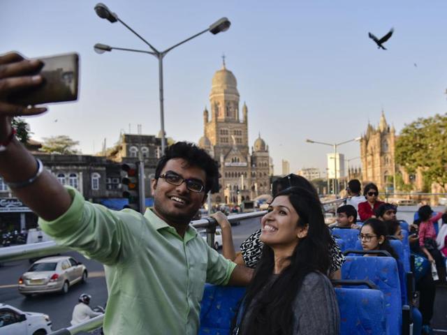 Revellers take selfies during a heritage bus ride as part of the Kala Ghoda Art Festival . (Satish Bate/ HT Photos)