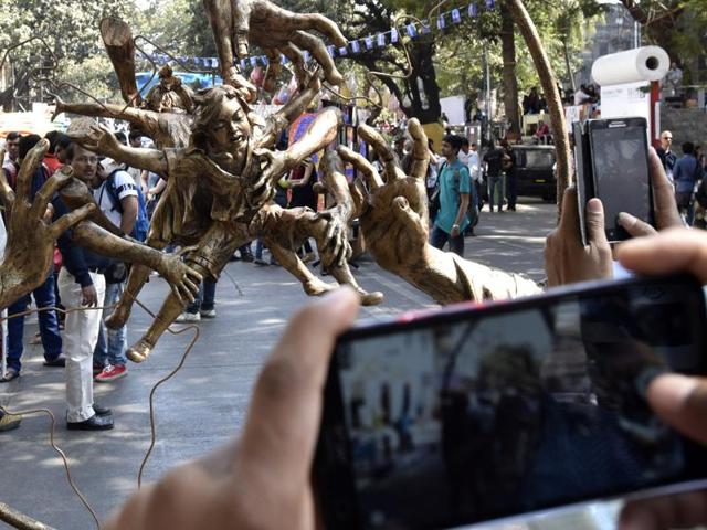 Revellers take pictures of a street art. (Kunal Patil/ HT Photos)