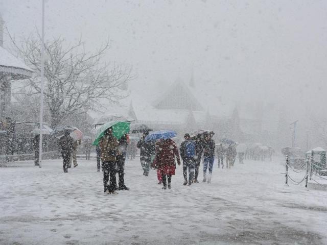 People walking during the first heavy snowfall at Ridge, Shimla on Sunday. (Deepak Sansta / Hindustan Times) People walking during the first heavy snowfall at Ridge, Shimla on Sunday. (Deepak Sansta / Hindustan Times)