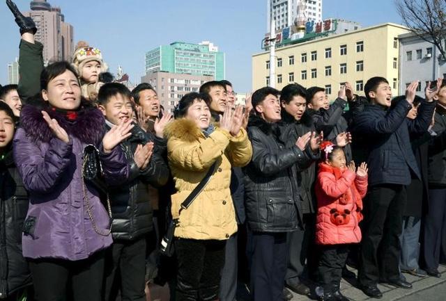 North Koreans watching a huge screen broadcasting an official announcement that the country "successfully" put an Earth observation satellite into orbit, calling it an "epoch-making" achievement, applaud in Pyongyang. (Reuters)