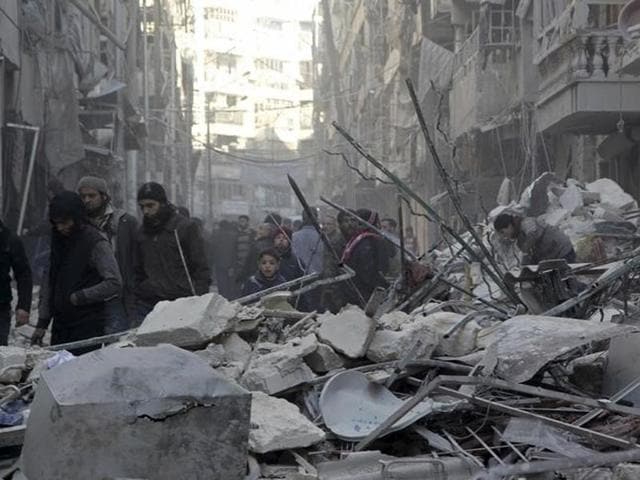 Birds are seen sitting on iron rods from the rubble of destroyed buildings amid heavily damaged buildings in the war ravaged city of Homs, Syria.(AFP Photo)