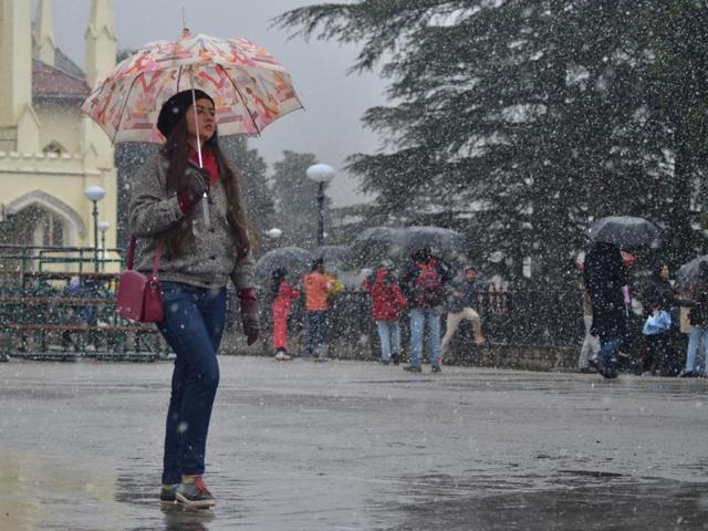 A woman walks in the snow at the Ridge in Shimla on Sunday. (photo: deepak sansta/ht)