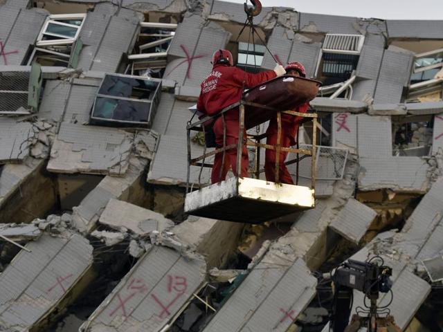 Two rescue workers bring down a victim from the collapsed Wei Kuan complex building in Tainan, southern Taiwan. (AFP Photo) Two rescue workers bring down a victim from the collapsed Wei Kuan complex building in Tainan, southern Taiwan. (AFP Photo)
