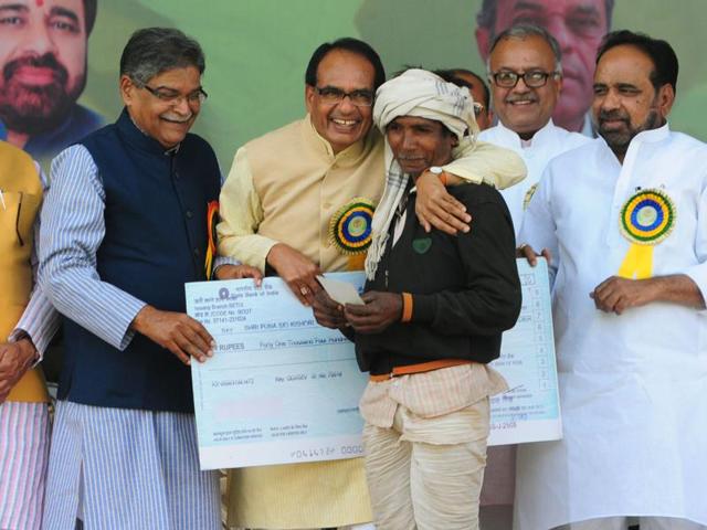 Chief minister Shivraj Singh Chouhan handing over bonus cheque to a tendu leaf plucker in Bhopal on Sunday. (Mujeeb Faruqui/ HT photo) Chief minister Shivraj Singh Chouhan handing over bonus cheque to a tendu leaf plucker in Bhopal on Sunday. (Mujeeb Faruqui/ HT photo)
