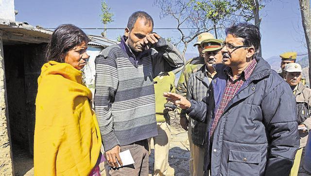 Garhwal range DFO Ramesh Chandra handed a cheque of Rs 90,000 to the grief-stricken family whose young son was killed by a leopard attack. (Arvind Moudgil/HT photo)