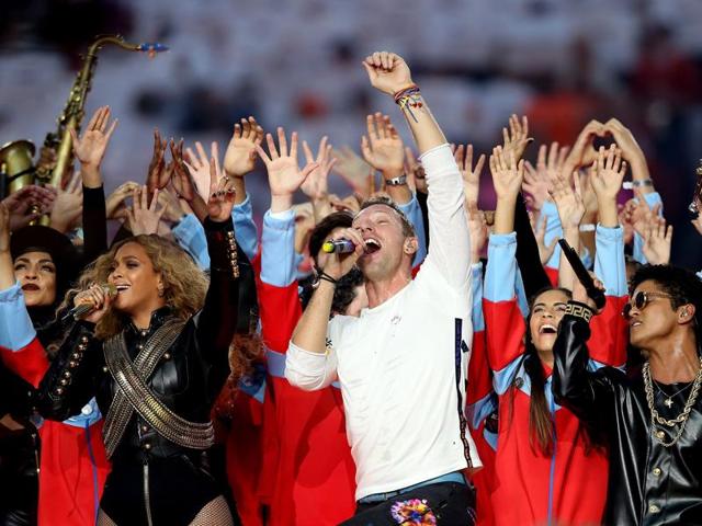 Beyonce, Chris Martin of Coldplay, and Bruno Mars put their hands in the air during the halftime show at the Super Bowl. (AFP)