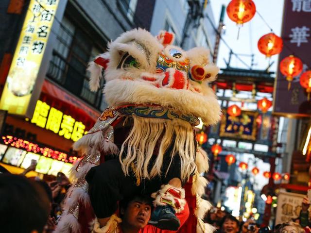 A man performs a lion dance outside a restaurant during celebrations in Chinatown in Yokohama, Tokyo, Japan, February 8, 2016. (REUTERS) 