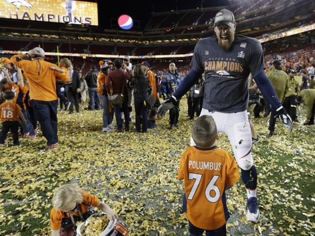 Denver Broncos’ Tyler Polumbus smiles as his kids Noah and Lydia play with the confetti after the NFL Super Bowl 50 football game. (AP Photo) 