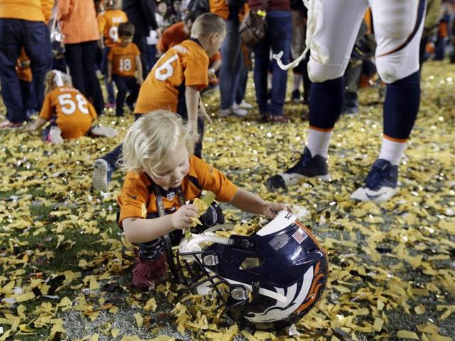 Denver Broncos’ Tyler Polumbus daughter Lydia plays with the confetti after the NFL Super Bowl. (AP Photo) 