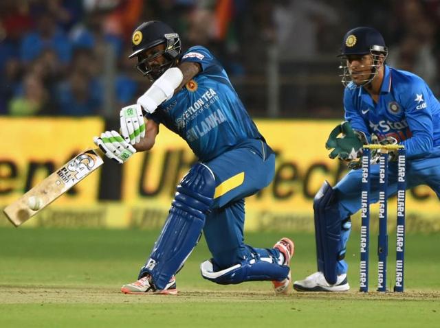 India's Mahendra Singh Dhoni (R) reacts as Sri Lanka's Chamara Kapugedera plays a shot during the first T20 international match between India and Sri Lanka at the MCA International Cricket Stadium in Pune on February 9, 2016.(AFP Photo)