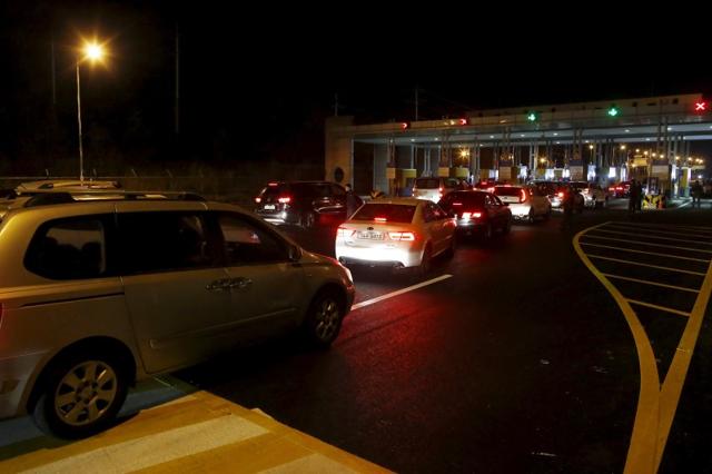 South Korean vehicles transporting employees working at the Kaesong Industrial Complex (KIC) wait to pass the gateway at the South's CIQ. (REUTERS)