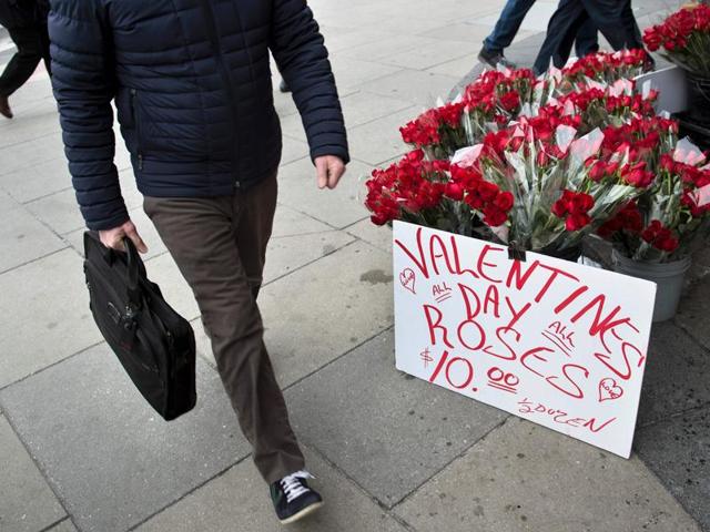 A man passes by a vender selling roses above a metro stop in Washington, DC on February 12, 2016. (AFP)