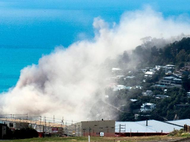 Dust and debris rise above houses after a cliff collapsed due to an earthquake on the Whitewash Head area, located above Scarborough Beach in the suburb of Sumner, Christchurch. (REUTERS)