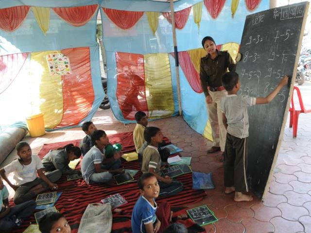 Sub-inspector Kanchan Singh teaches kids at the at Hanumanganj police station in Bhopal.(Praveen Bajpai/HT) Sub-inspector Kanchan Singh teaches kids at the at Hanumanganj police station in Bhopal.(Praveen Bajpai/HT)