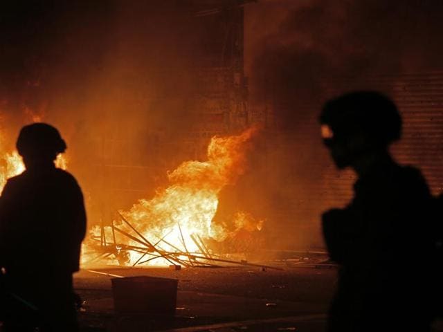 In this Tuesday, February 9, 2016 photo, police officers walk past a blazing fire set by protestors in Mong Kok district of Hong Kong. (AP) In this Tuesday, February 9, 2016 photo, police officers walk past a blazing fire set by protestors in Mong Kok district of Hong Kong. (AP)