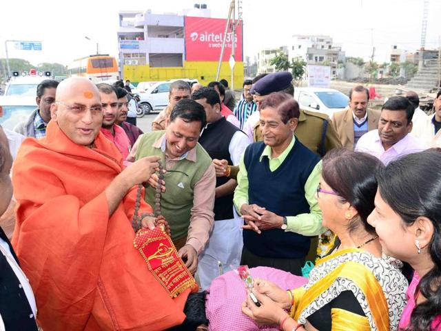 Acharya Mahamandleshwar Avdheshanand Giri being welcomed by disciples in Ujjain on Tuesday.(HT photo)