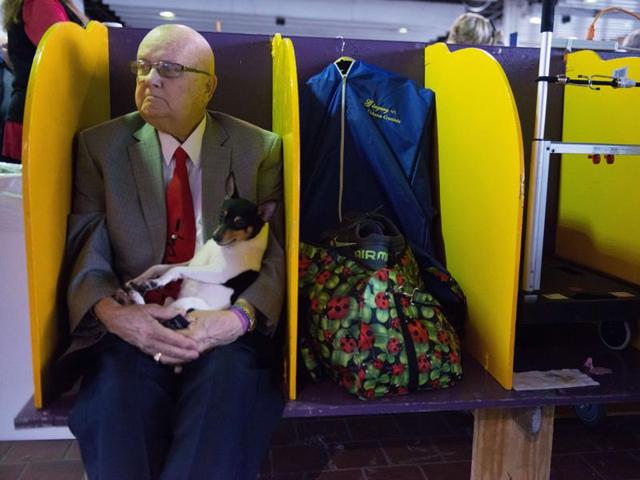 A man sits with his dog after competition. (AFP) 