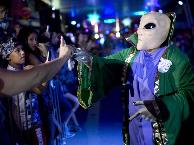 In this Feb. 12, 2016 photo, a man decked out in an alien costume makes hand gestures with the public during a parade at the annual Alien Festival in Capilla del Monte, Cordoba, Argentina, the site of an alleged UFO sighting 30 years ago. The sighting left a mark in the economy of the town, which has flourished with its alien tourism. (AP Photo/Natacha Pisarenko) (AP) In this Feb. 12, 2016 photo, a man decked out in an alien costume makes hand gestures with the public during a parade at the annual Alien Festival in Capilla del Monte, Cordoba, Argentina, the site of an alleged UFO sighting 30 years ago. The sighting left a mark in the economy of the town, which has flourished with its alien tourism. (AP Photo/Natacha Pisarenko) (AP)