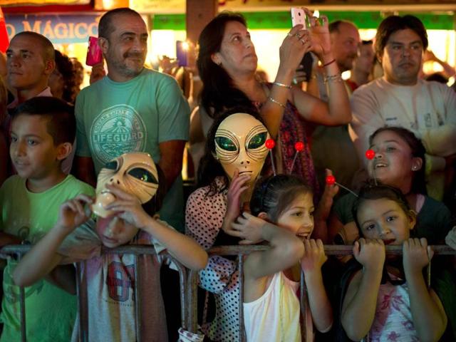 In this Feb. 13, 2016 photo, tourists watch an alien parade during the annual Alien Festival in Capilla del Monte, Cordoba, Argentina, the site of an alleged UFO sighting 30 years ago. The festival, currently hosting its fourth edition, has caused some controversy as the more fervent believers feel it has put a frivolous twist on what they consider a serious phenomenon. (AP Photo/Natacha Pisarenko) (AP) In this Feb. 13, 2016 photo, tourists watch an alien parade during the annual Alien Festival in Capilla del Monte, Cordoba, Argentina, the site of an alleged UFO sighting 30 years ago. The festival, currently hosting its fourth edition, has caused some controversy as the more fervent believers feel it has put a frivolous twist on what they consider a serious phenomenon. (AP Photo/Natacha Pisarenko) (AP)