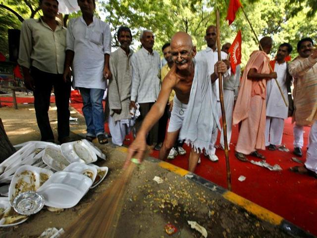 Dr Mahesh Chaturvedi, dressed like Mahatma Gandhi, sweeps a street in Jantar Mantar, New Delhi expressing his support for PM Modi's 'Swachh Bharat' campaign.(Raj k Raj/HT File Photo)