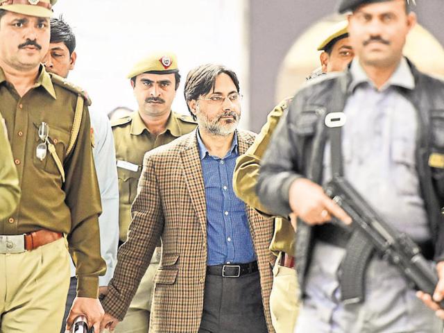 Delhi Police officers with SAR Geelani, the Delhi University lecturer was booked for sedition on early Tuesday morning for allegedly organising the Afzal Guru event at the Press Club of India. (Sonu Mehta/HT Photo)
