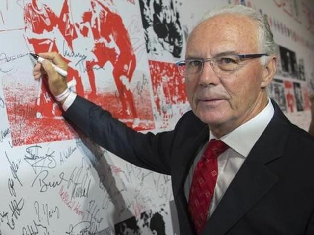 Former player and coach Franz Beckenbauer signs a wall of fame at a gala marking the 50th anniversary of the foundation of the German Bundesliga.(Reuters Photo)
