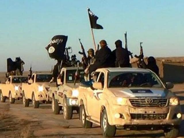 Militants of the Islamic State group are seen holding up their weapons and waving IS flags in Syria in this undated file photo released online in the summer of 2014 on a militant social media account. The extremist group that once bragged about minting its own currency is now accepting only US dollars in Raqqa, slashing salaries across the board and imposing “exit fees” for those trying to leave its domain. (AP File Photo) Militants of the Islamic State group are seen holding up their weapons and waving IS flags in Syria in this undated file photo released online in the summer of 2014 on a militant social media account. The extremist group that once bragged about minting its own currency is now accepting only US dollars in Raqqa, slashing salaries across the board and imposing “exit fees” for those trying to leave its domain. (AP File Photo)