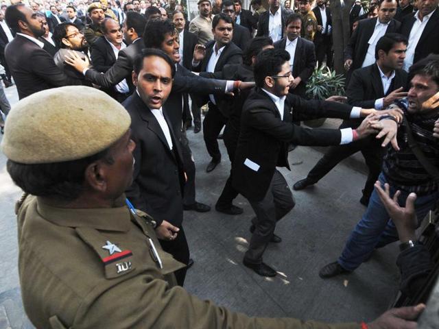 Lawyers assaulting a journalist outside Patiala House Court in New Delhi on Wednesday. (HT Photo)