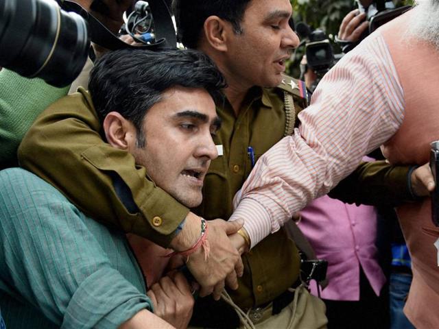 A policeman tries to save a JNU student who was being beaten up during a clash between the advocates and the students outside the Patiala House Courts in New Delhi on Monday.(PTI)