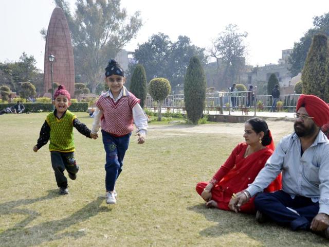 Children with parents at Jallianwala Bagh as sun shines in Amritsar on Thursday. (HT Photo )