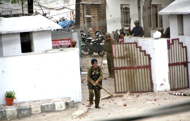 A policeman throws stones at protesting Jat students in front of IGP office in Rohtak. (Manoj Dhaka/HT Photo) A policeman throws stones at protesting Jat students in front of IGP office in Rohtak. (Manoj Dhaka/HT Photo)